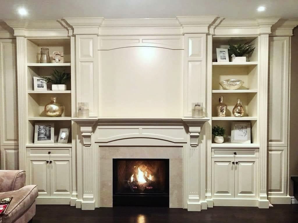 Detailed fireplace surround and built-in cabinetry by LG Woodworking